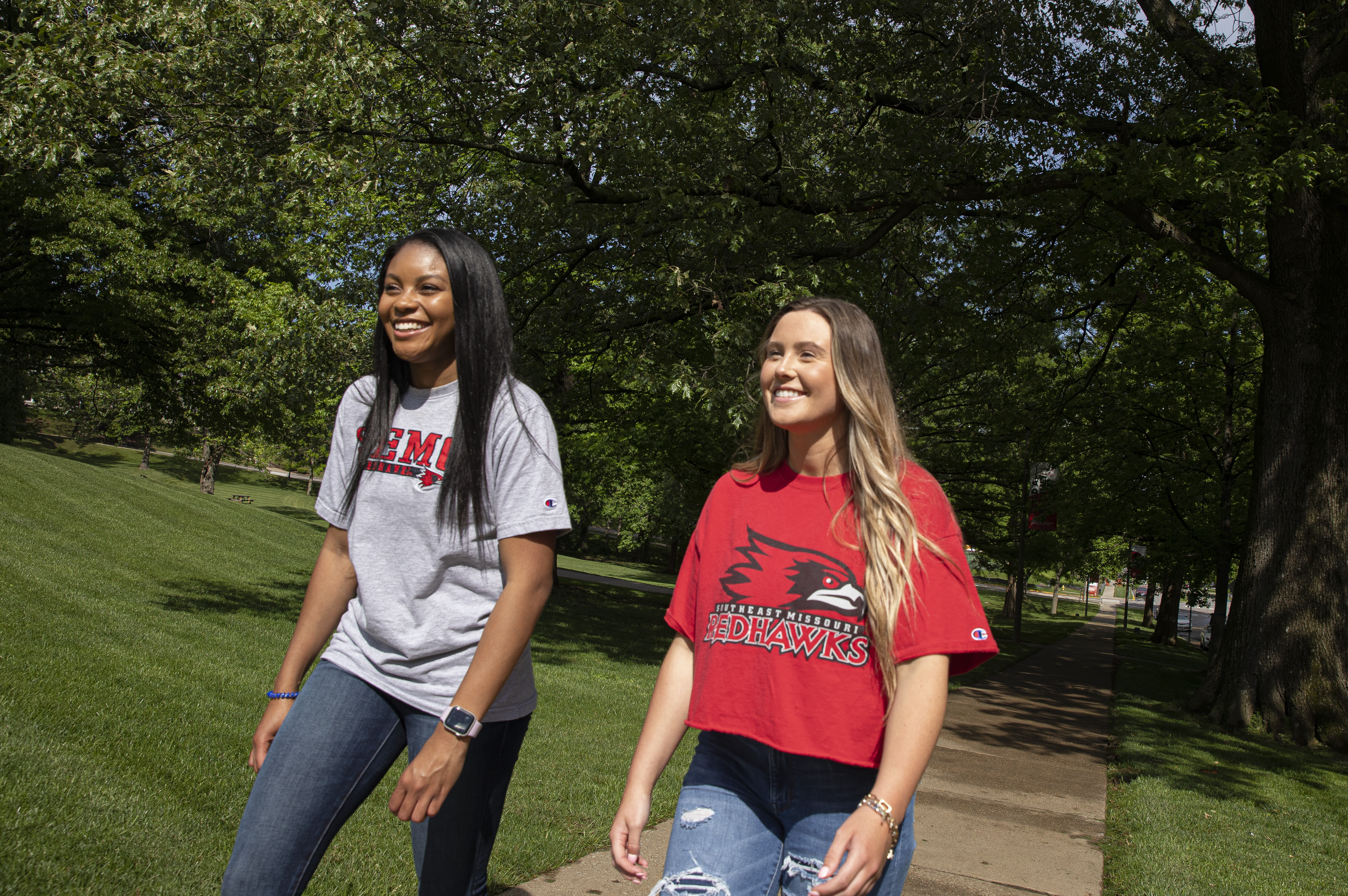 Students in SEMO attire smile while walking across campus.