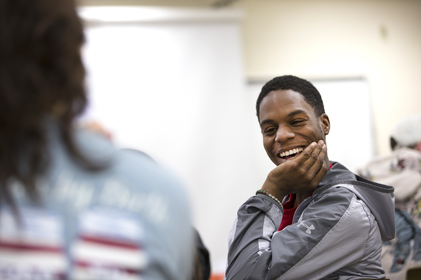 A student laughs while talking with a peer in a psychology class.