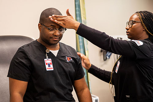 Nursing students practice checking temperatures.